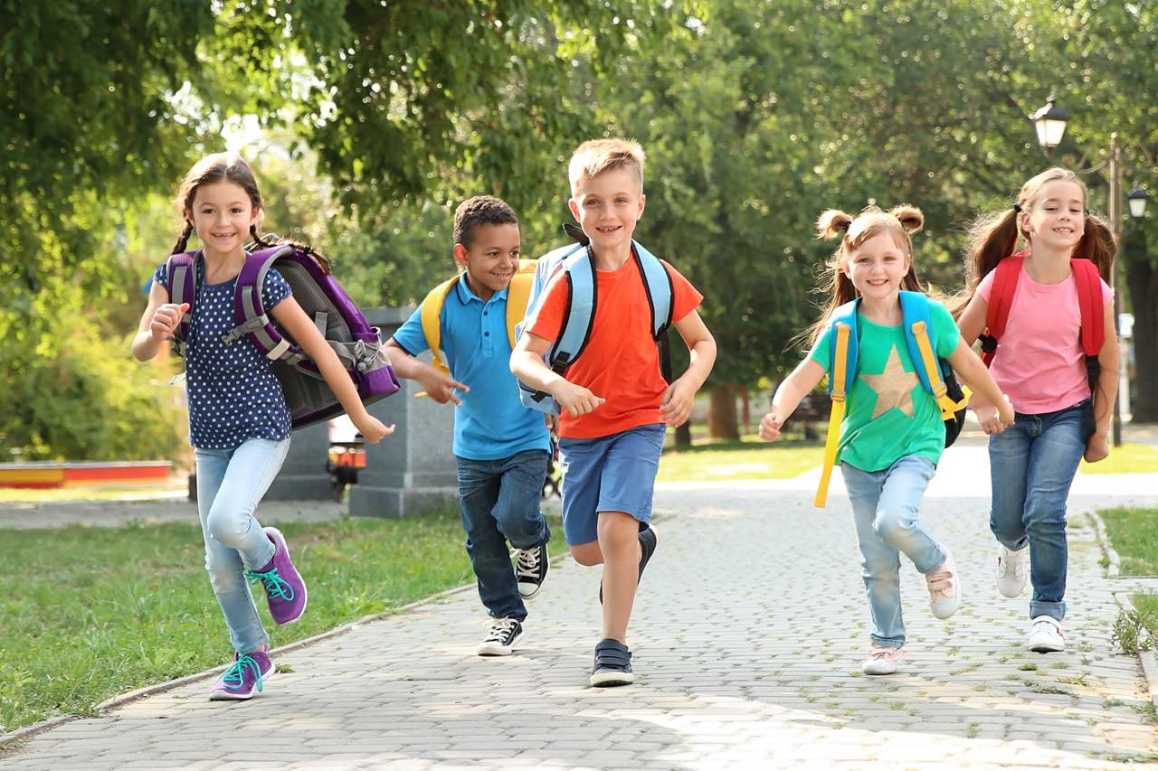 Eine Gruppe Schüler rennt auf einem Weg im Park.